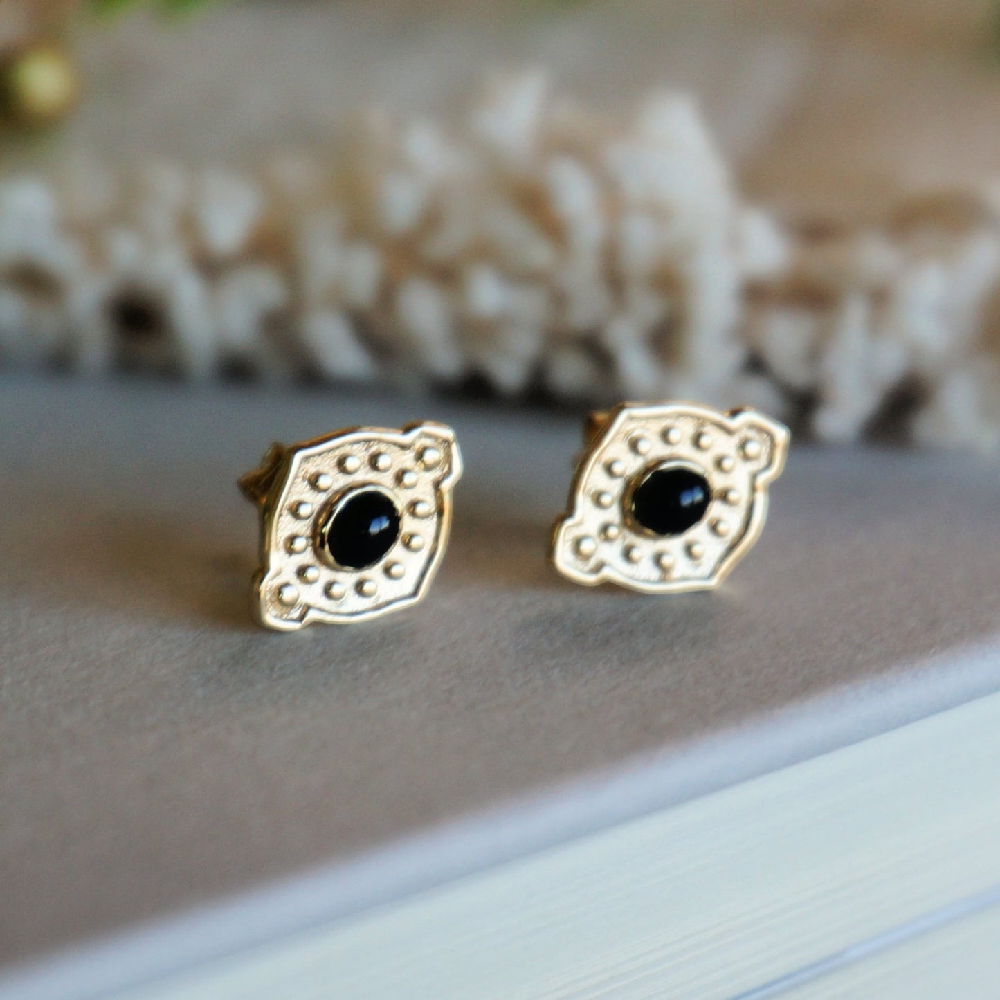 SOWELL JEWELRY vintage-inspired 18k gold stud earrings featuring a central black onyx stone and textured metal details.