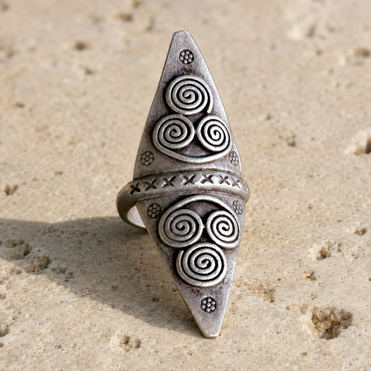 SOWELL JEWELRY Anada sterling silver statement ring with intricate etched spiral patterns on a textured stone surface.