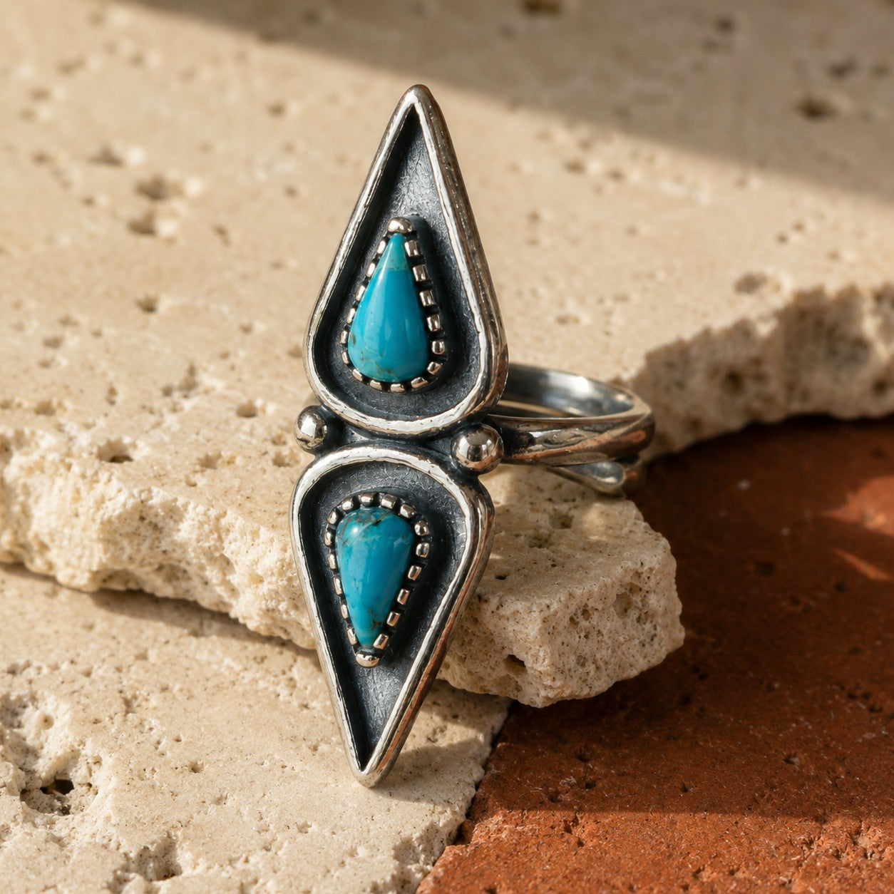 SOWELL JEWELRY Elan turquoise ring featuring two pear-shaped stones set in an oxidized sterling silver frame.