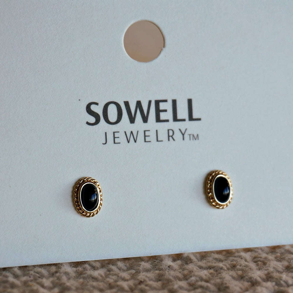 SOWELL JEWELRY Fala stud earrings featuring oval black onyx stones in braided 18k gold-plated frames on display card.