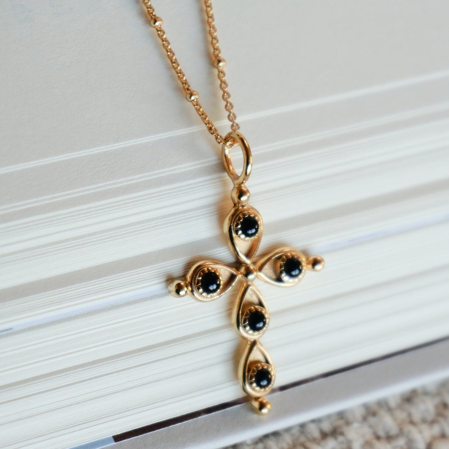 SOWELL JEWELRY 18k gold plated cross pendant necklace featuring black onyx stones on a dainty gold ball chain