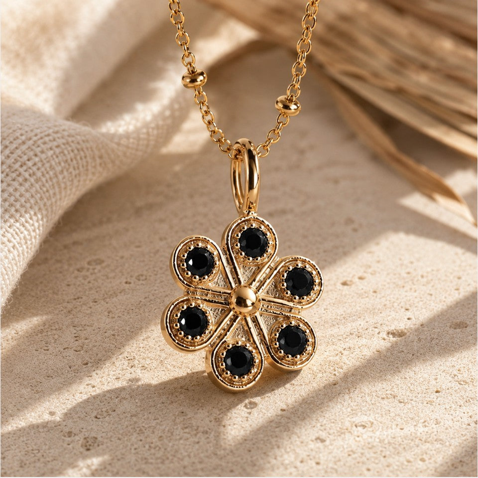 SOWELL JEWELRY 18K gold floral pendant necklace featuring six black onyx stones on a delicate beaded chain