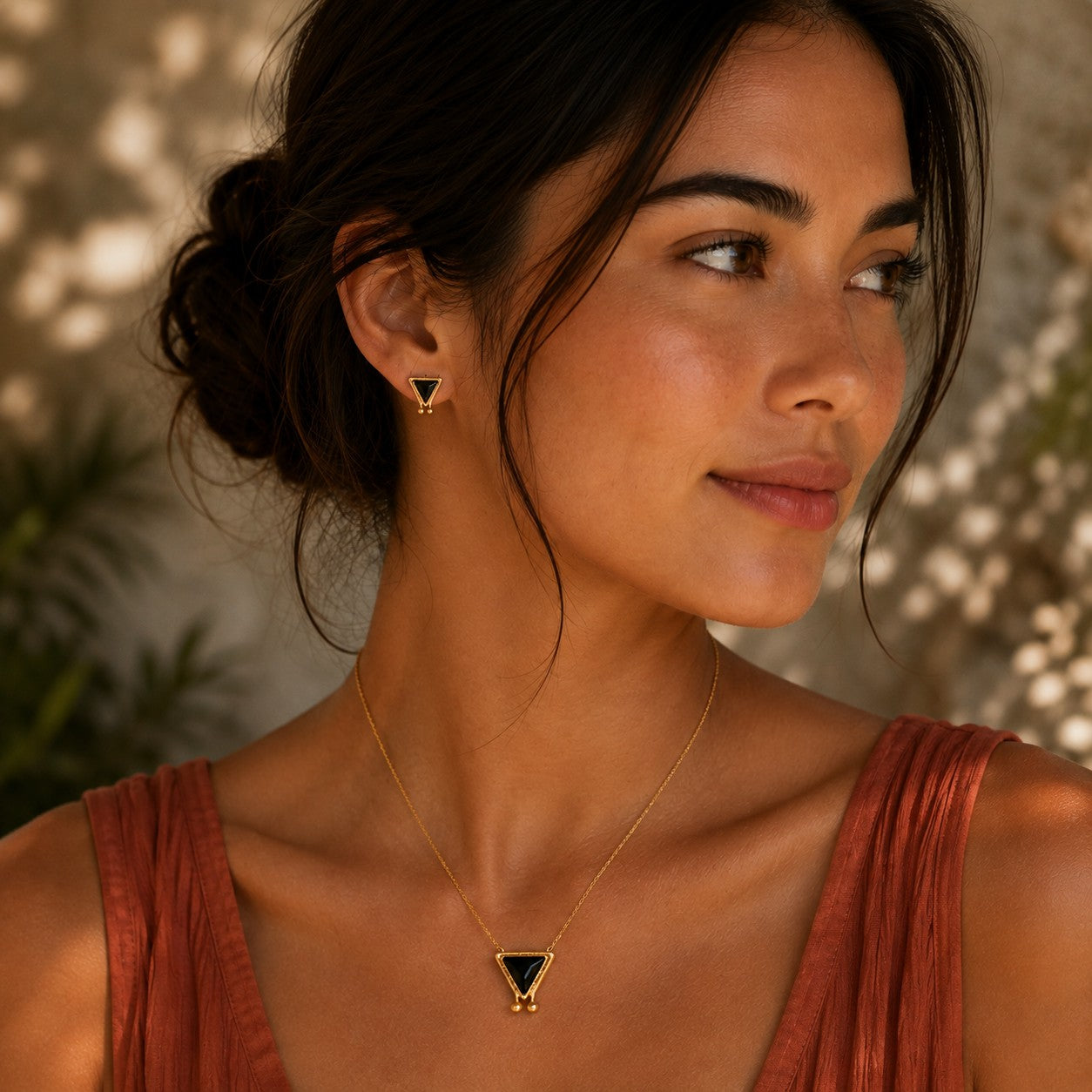 SOWELL JEWELRY Hanale triangle stud earrings in 18k gold vermeil with black onyx worn by a woman