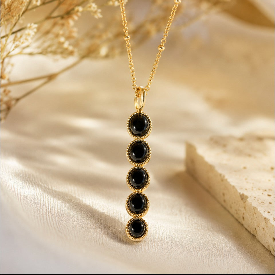 SOWELL JEWELRY Ilaria necklace featuring five round black onyx stones in a vertical 18k gold plated setting.