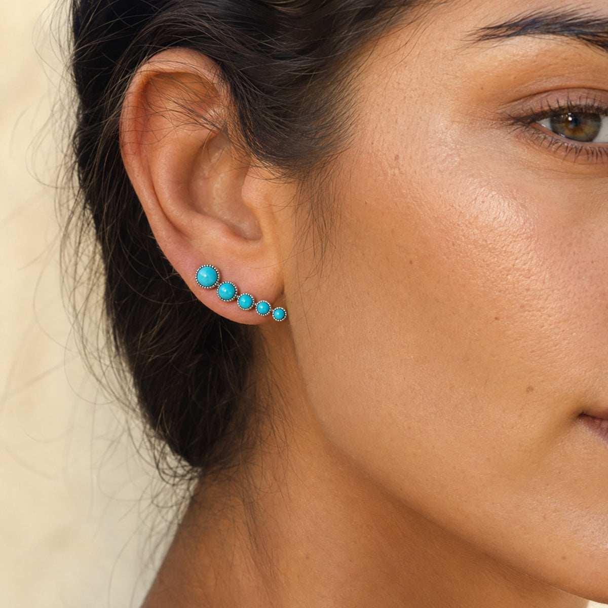 SOWELL JEWELRY Ilaria turquoise earrings featuring five round stones in a sterling silver cascade worn on an earlobe