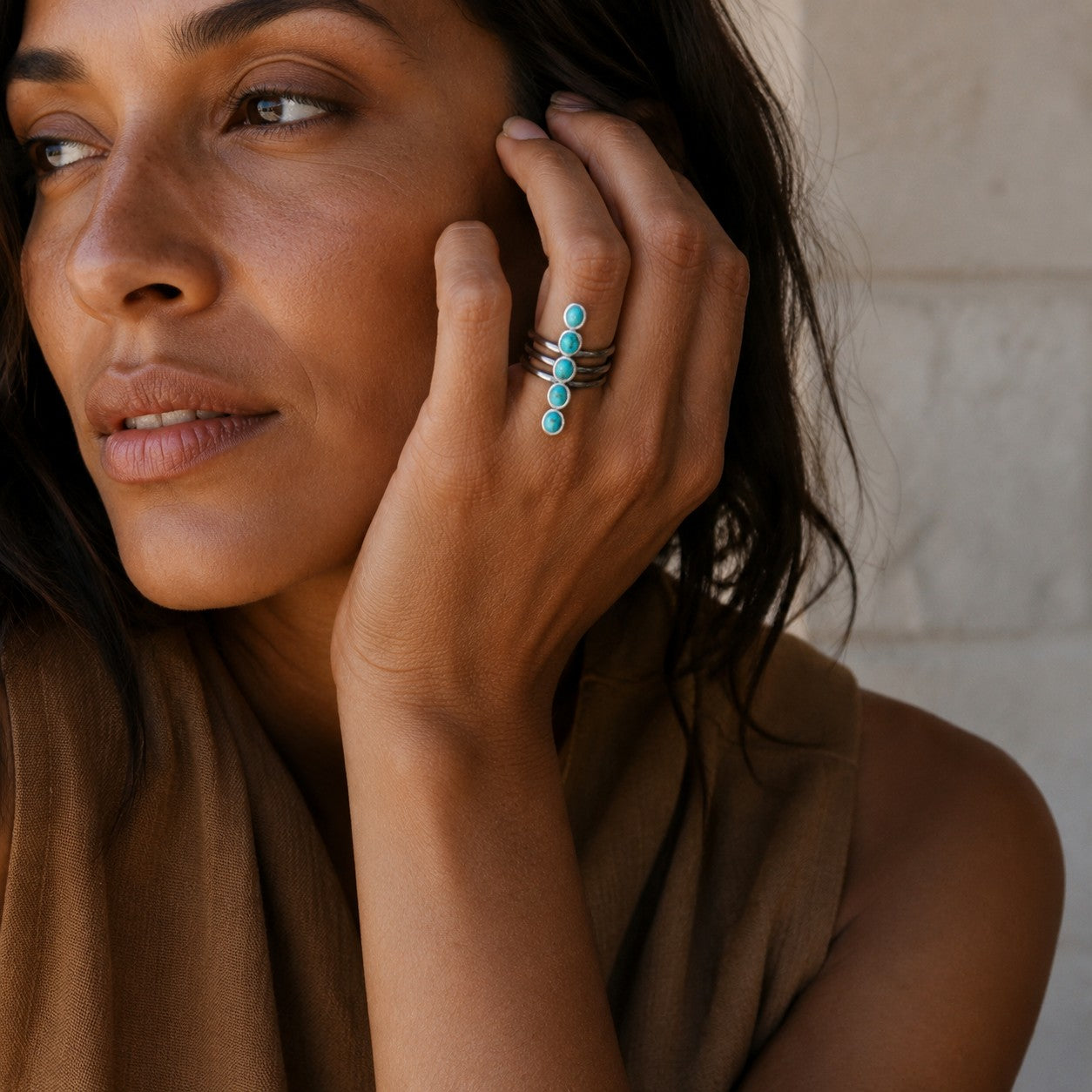 SOWELL JEWELRY Kachada ring with turquoise stones in sterling silver worn by a woman with a hand on her face