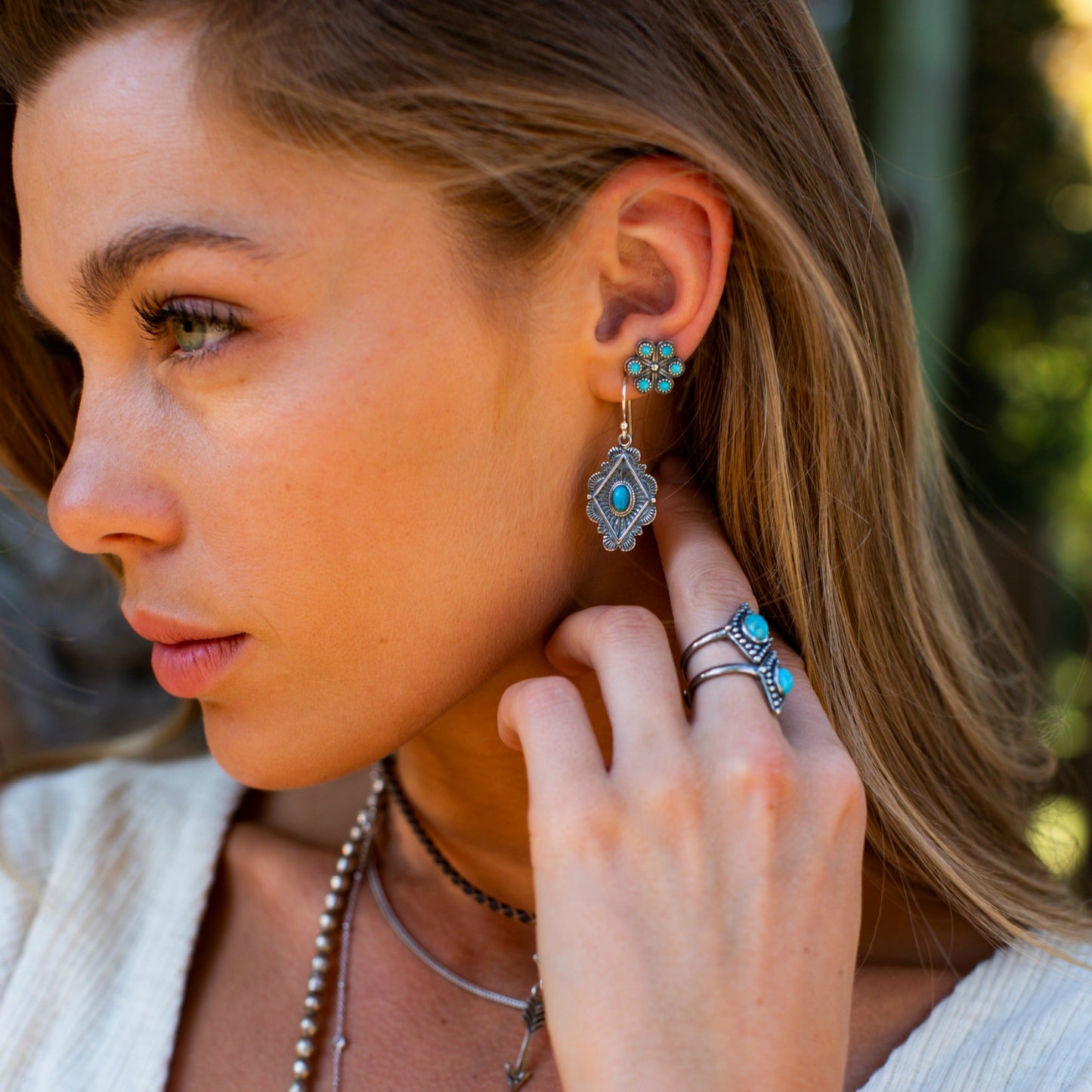 SOWELL JEWELRY Leif earrings featuring oval turquoise stones set in sterling silver worn by a woman