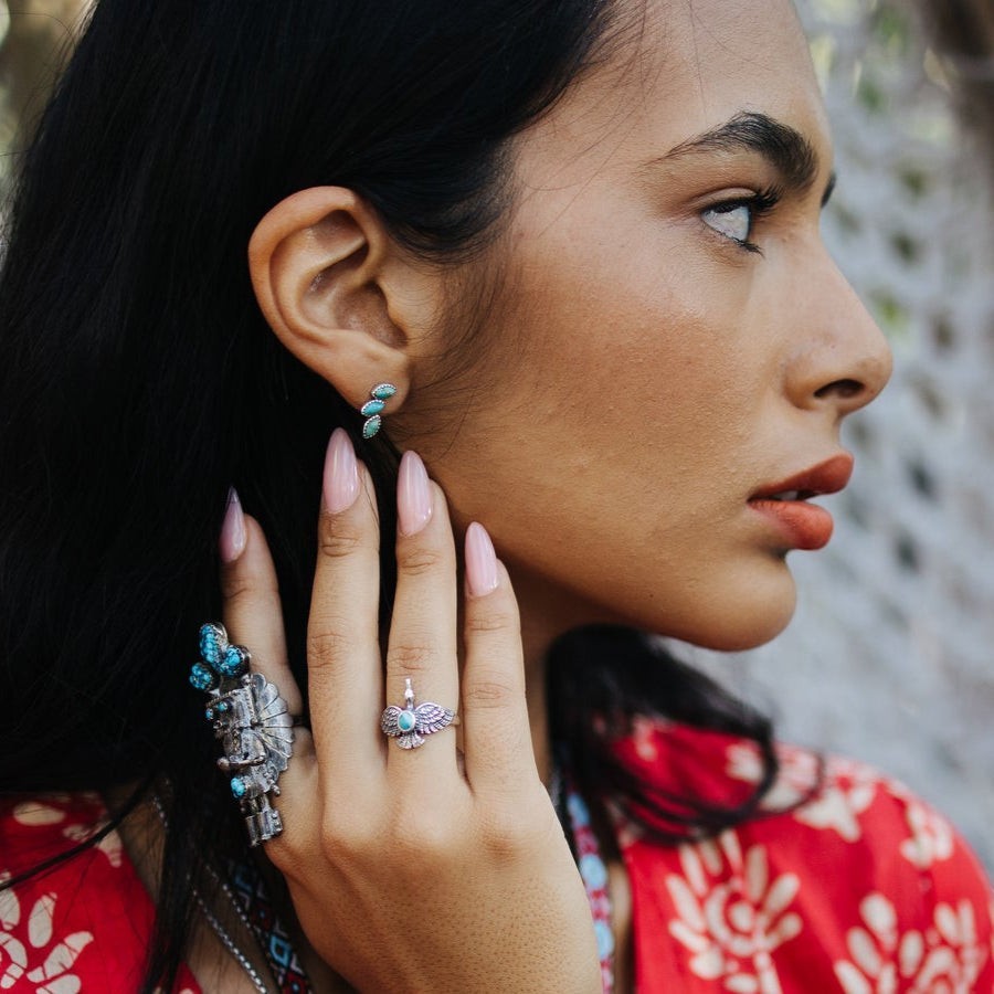 SOWELL JEWELRY Lyra turquoise earrings in sterling silver worn by a woman with a boho ring set