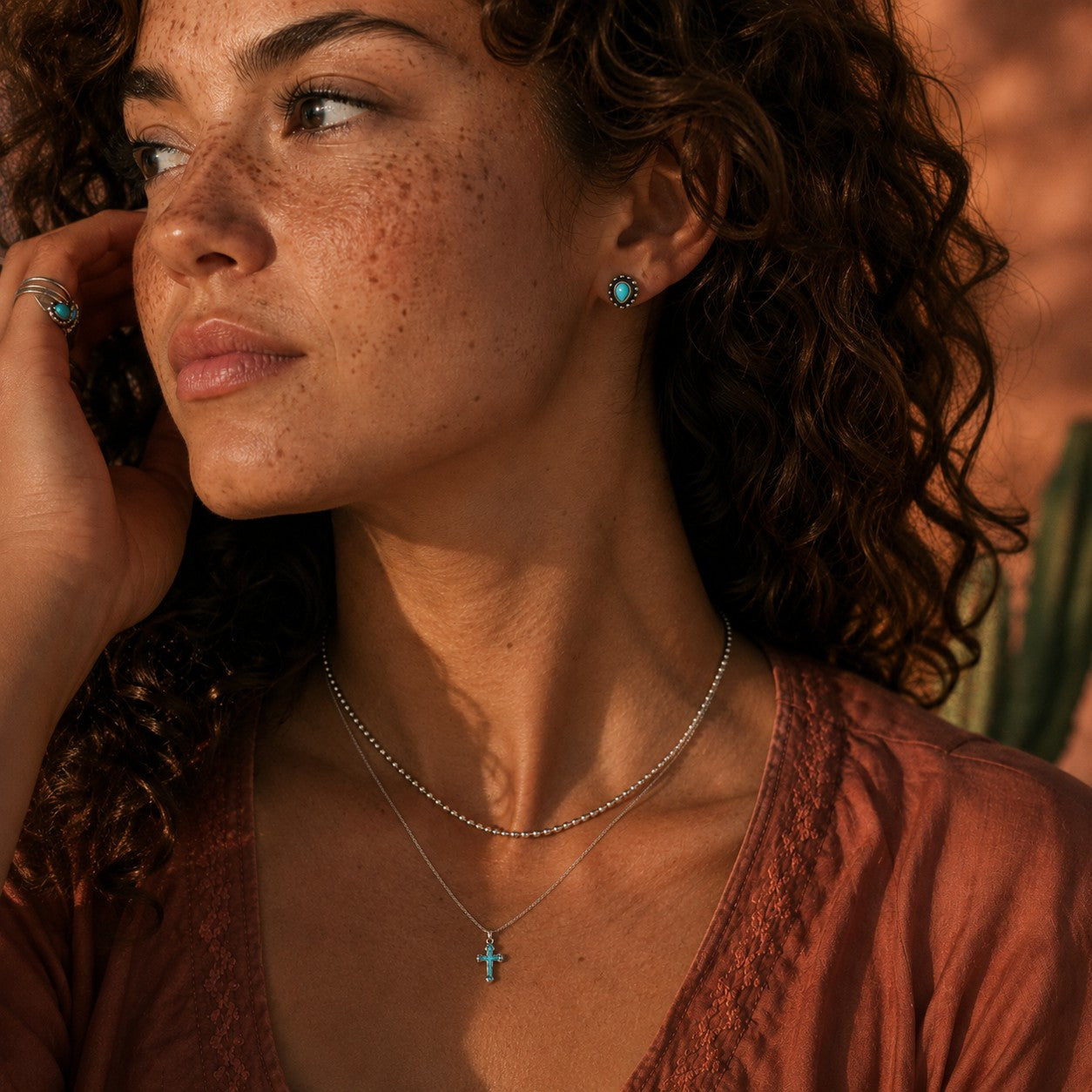SOWELL JEWELRY Maya stud earrings featuring genuine turquoise in handcrafted sterling silver worn by a woman
