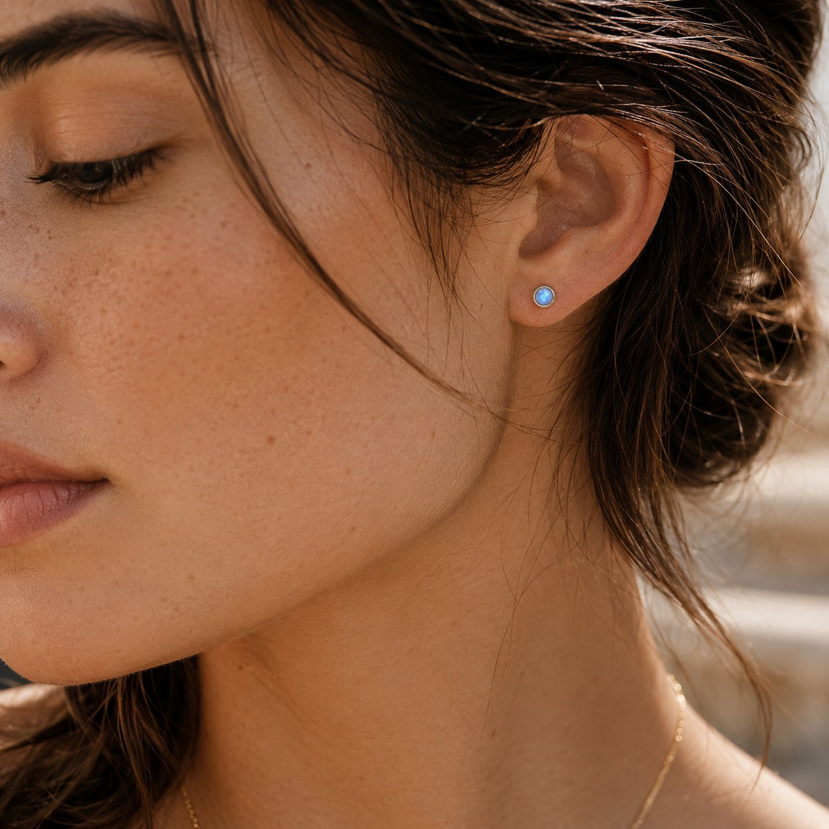 SOWELL JEWELRY minimalist stud earrings featuring a 4mm rainbow moonstone set in .925 sterling silver on a woman
