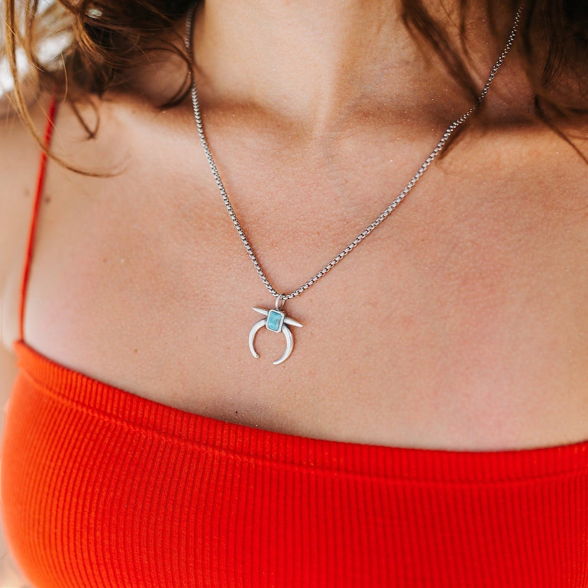 SOWELL JEWELRY Naja crescent turquoise pendant necklace in sterling silver worn on a model with an orange top