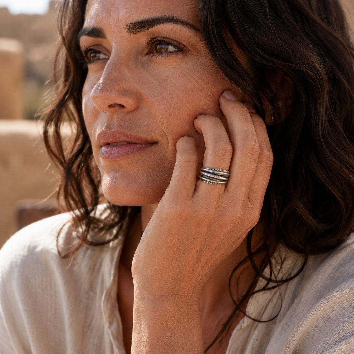 SOWELL JEWELRY handcrafted sterling silver leaf band ring worn by a woman with wavy hair in a desert setting