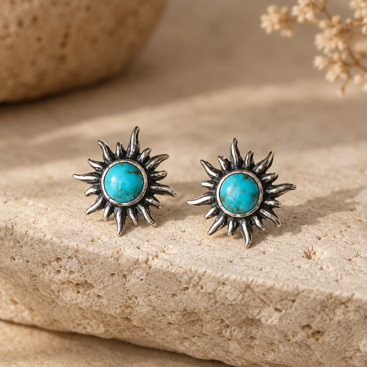 SOWELL JEWELRY sunburst turquoise stud earrings in handcrafted .925 sterling silver on a textured stone surface.