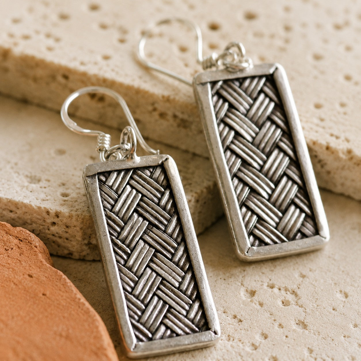 SOWELL JEWELRY Tao sterling silver earrings featuring a geometric woven basket pattern on a textured stone background.