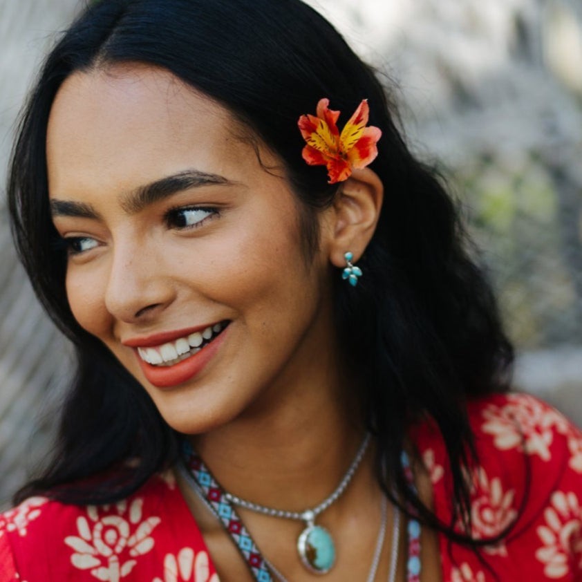 SOWELL JEWELRY Three Leaves earrings featuring blue turquoise stones set in sterling silver on a smiling woman