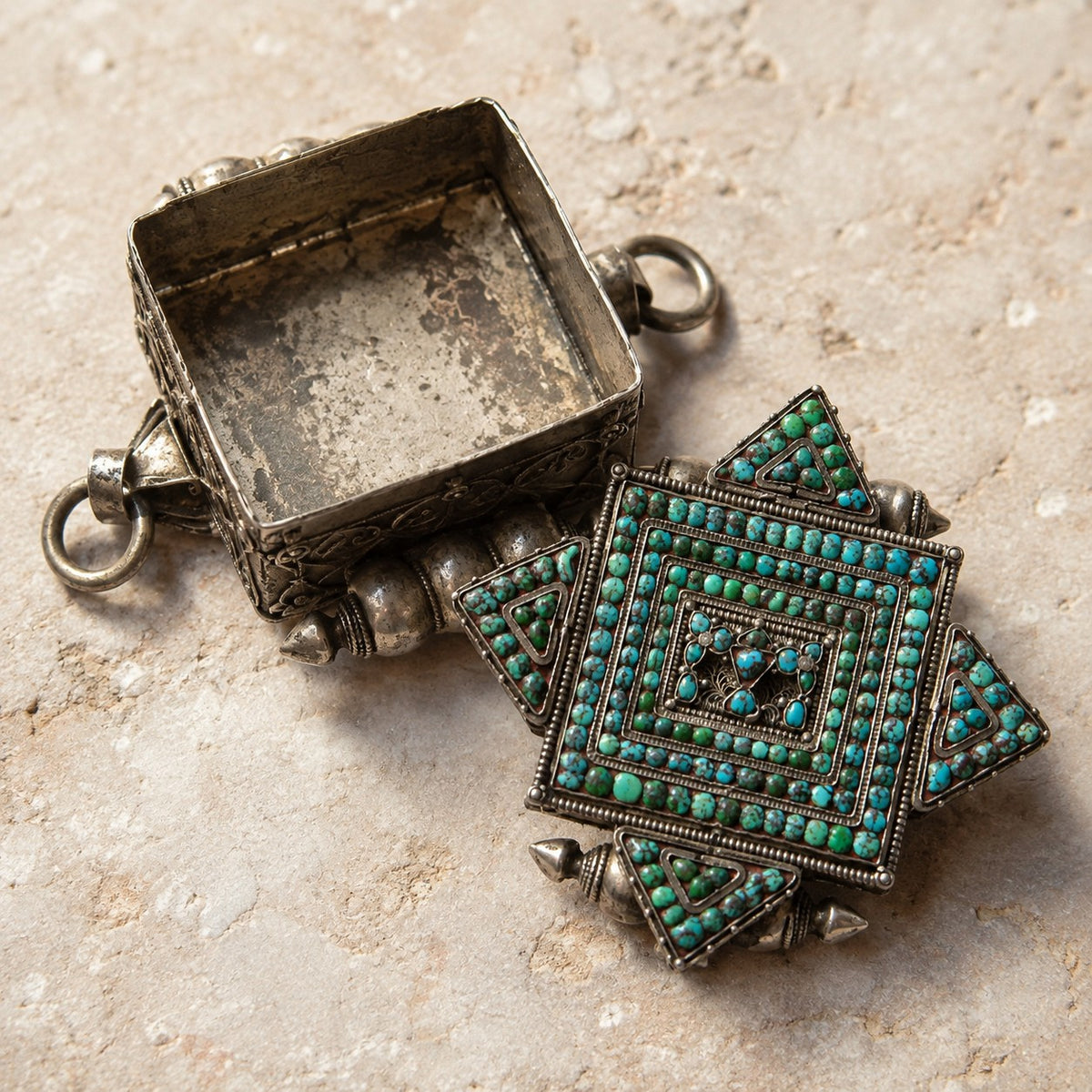 SOWELL JEWELRY sterling silver Tibetan gau box pendant with intricate turquoise mosaic, shown open on stone surface.