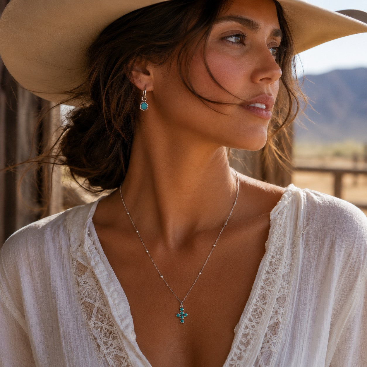 SOWELL JEWELRY Desert Cross turquoise pendant necklace in sterling silver worn by a woman in a desert setting