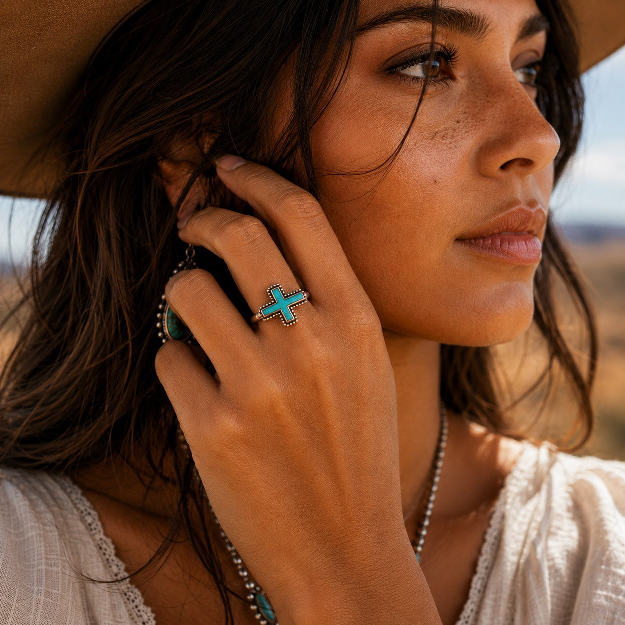 SOWELL JEWELRY sterling silver cross ring with genuine turquoise stone worn by a woman in a boho setting