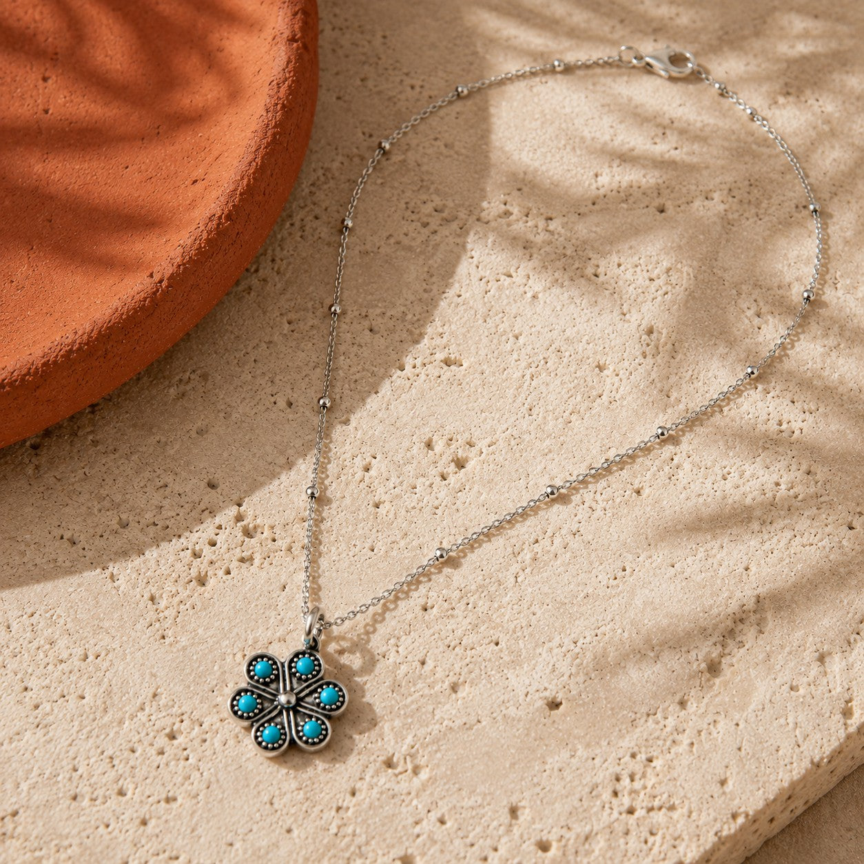 SOWELL JEWELRY Iris flower necklace featuring a turquoise stone set in handcrafted .925 sterling silver on a chain.