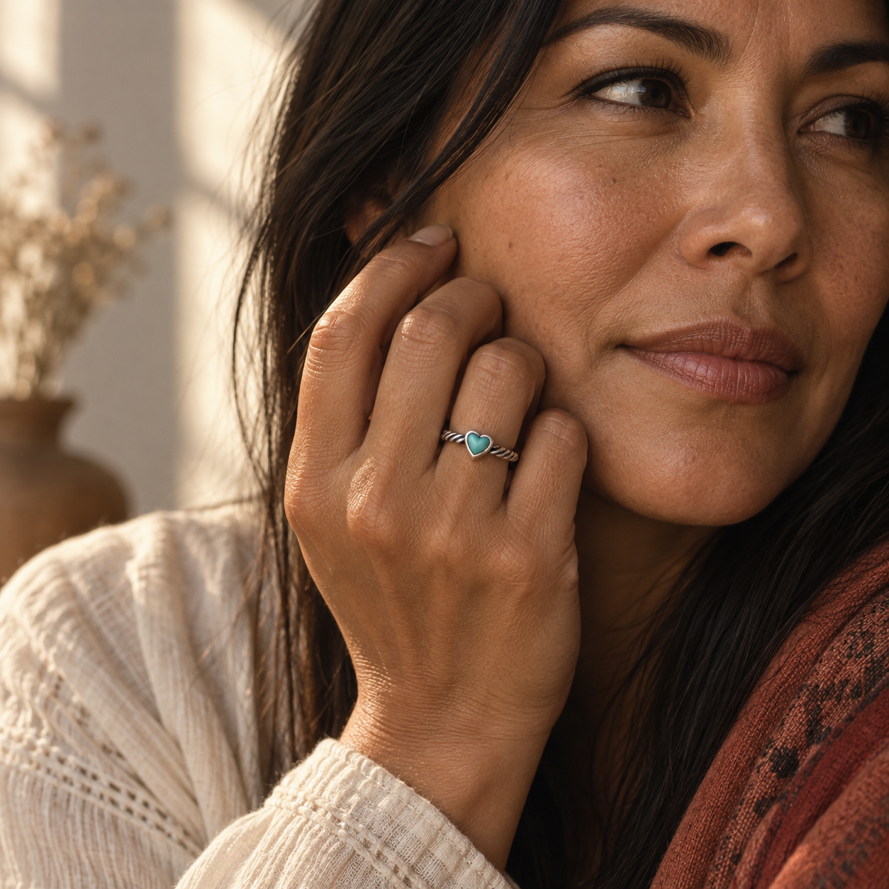SOWELL JEWELRY heart-shaped turquoise stone ring in sterling silver worn on a woman's finger in a boho style.