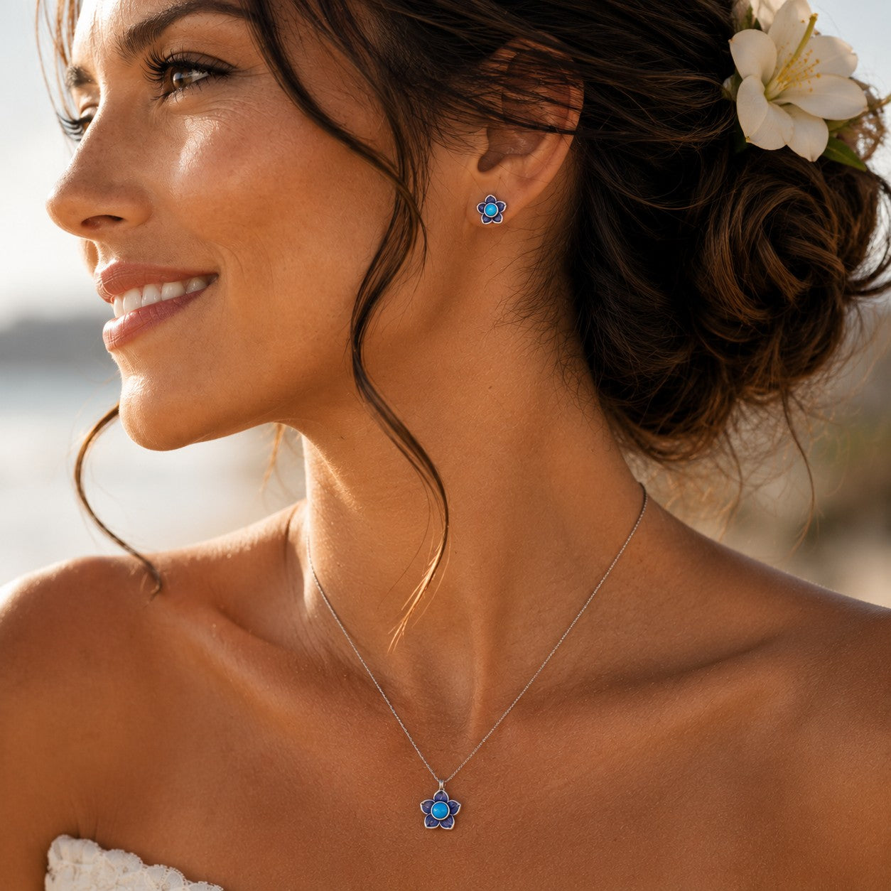 SOWELL JEWELRY turquoise plumeria flower earrings and matching necklace worn by a smiling woman with a floral hairpiece