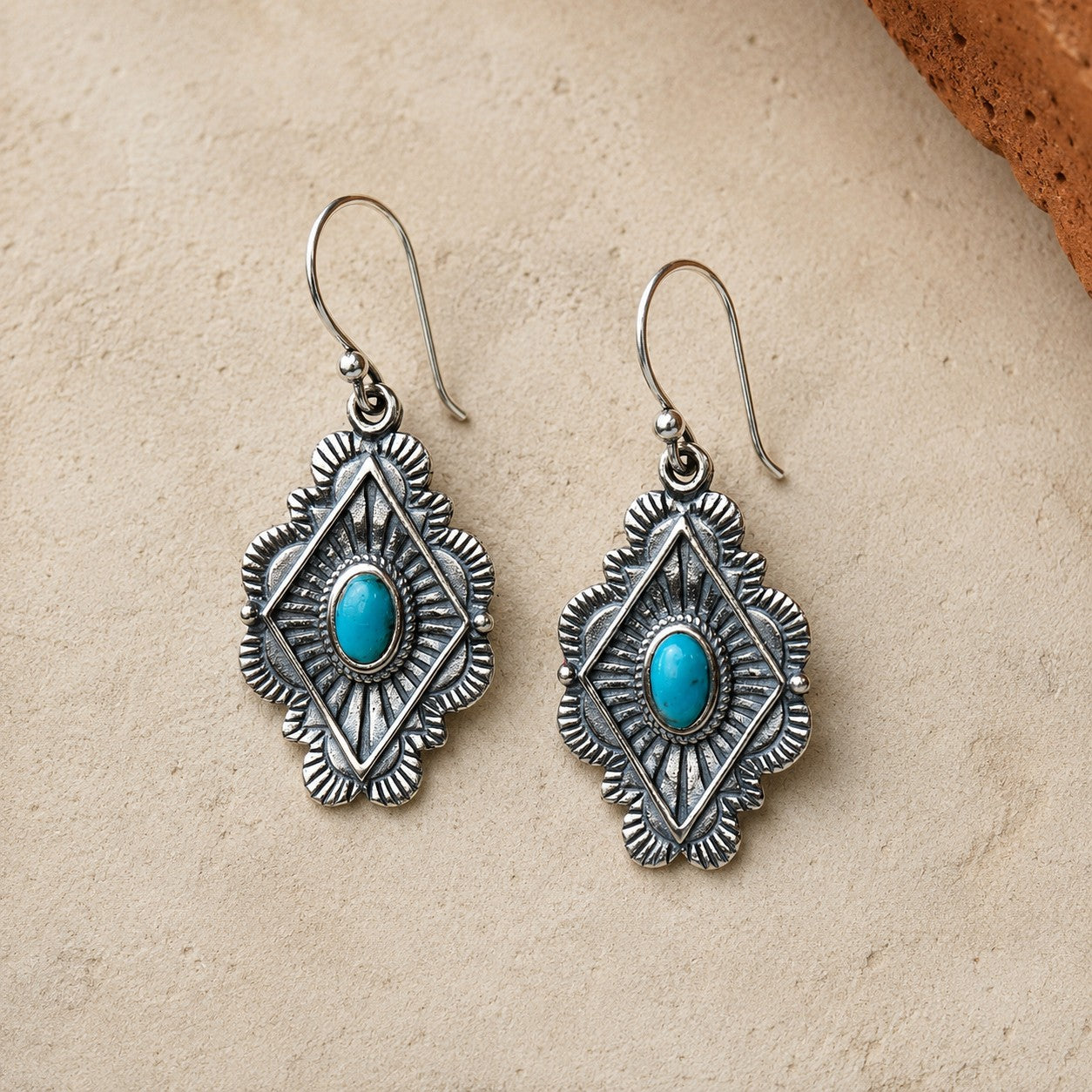SOWELL JEWELRY Leif earrings featuring oval turquoise stones set in ornate sterling silver with a geometric design.