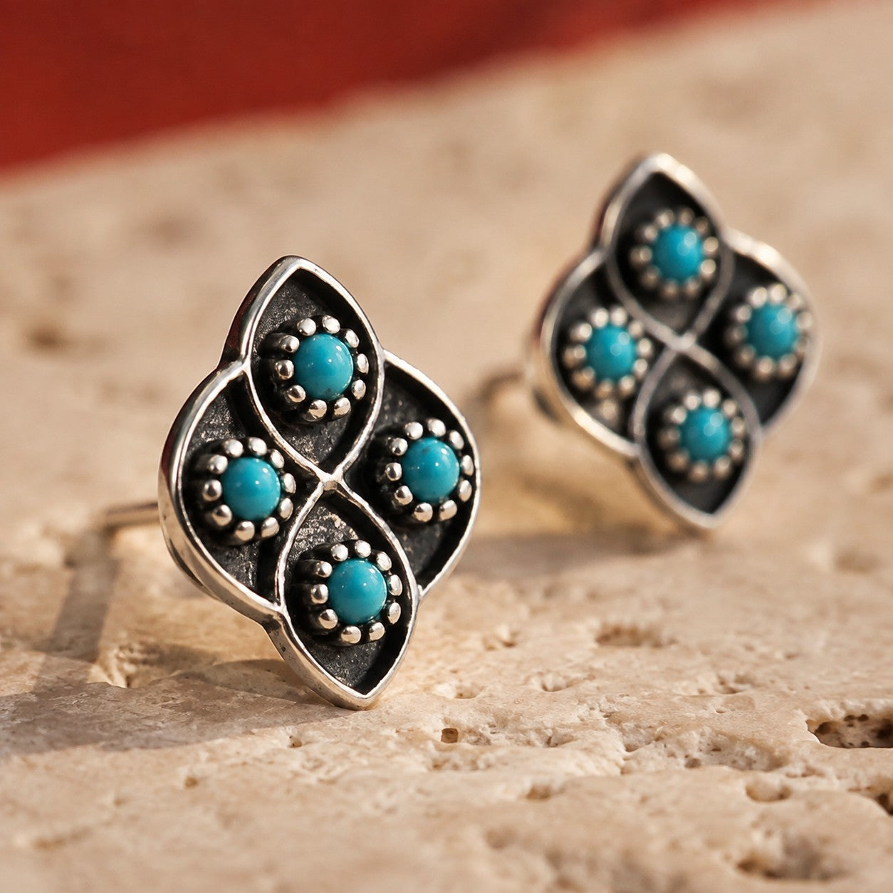 SOWELL JEWELRY Lucia stud earrings featuring round turquoise stones set in textured sterling silver with a floral shape.