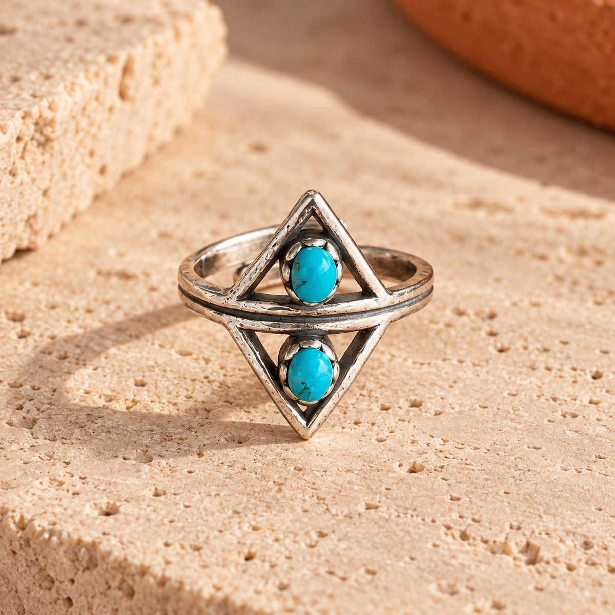 SOWELL JEWELRY Aurelia ring featuring two turquoise cabochons in an oxidized sterling silver geometric triangle frame.