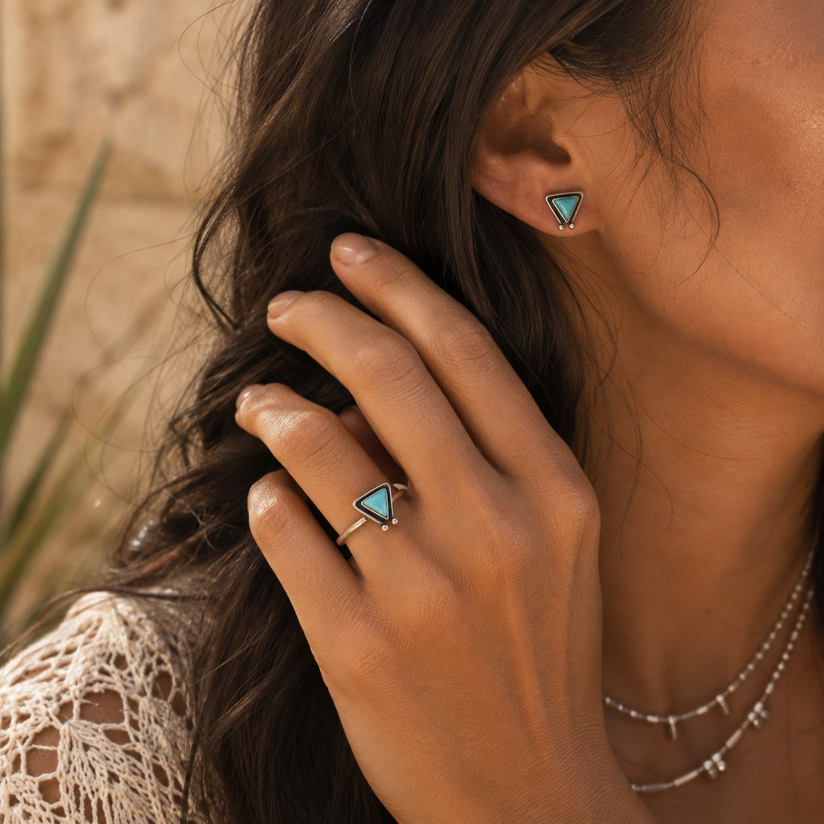 SOWELL JEWELRY Hanale triangle turquoise stud earrings in sterling silver worn by a woman with matching ring