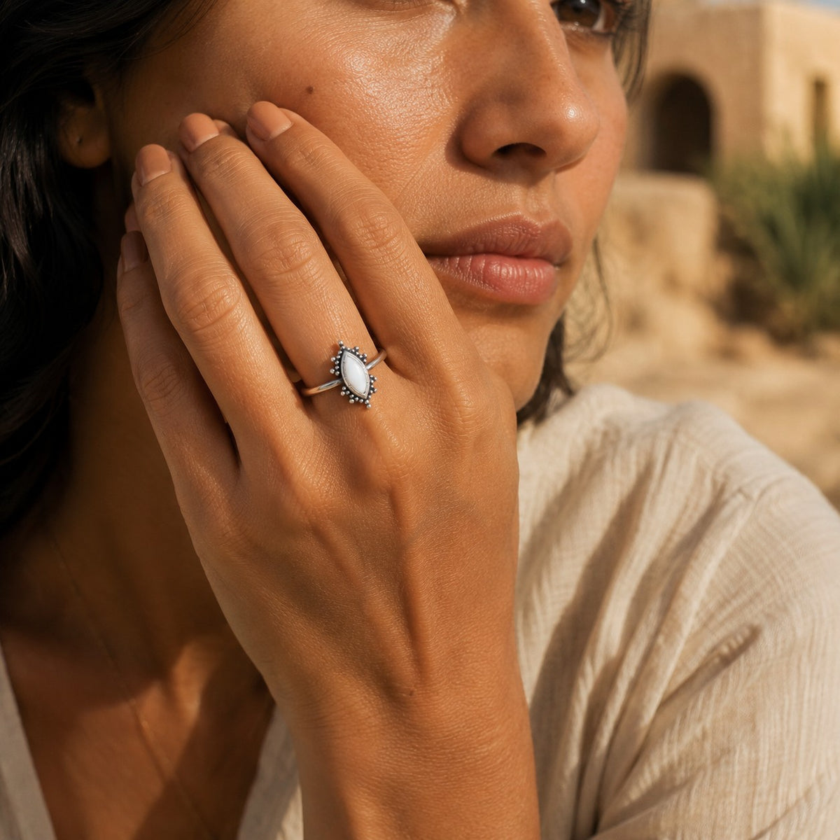 SOWELL JEWELRY Kal ring featuring a marquise-cut white agate stone in a sterling silver setting on a woman's finger.